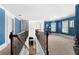 Bright hallway with a decorative railing overlooking the stairs and a large, open carpeted area at 2745 Veltre Sw Ter, Atlanta, GA 30311