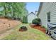 Grassy backyard features a brick fire pit with trees and shrubs at 2920 Olde Towne Pkwy, Duluth, GA 30097