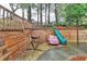 This backyard features a hammock, slide, play car and a wooded landscape at 2920 Olde Towne Pkwy, Duluth, GA 30097