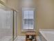Bathroom with glass shower and soaking tub under a window with wooden shutters at 2920 Olde Towne Pkwy, Duluth, GA 30097