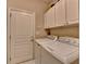 Convenient laundry room with cabinets and a front loading washer and dryer at 2920 Olde Towne Pkwy, Duluth, GA 30097