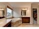 Well lit bathroom features a large tub, double sinks and a window overlooking the yard at 4650 Sandy Creek Dr, Cumming, GA 30028