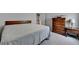 Well-lit bedroom featuring neutral walls, carpeted floor, and a dark wooden dresser at 4650 Sandy Creek Dr, Cumming, GA 30028