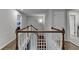 Upstairs hallway with white walls and railing, and hardwood floors at 4650 Sandy Creek Dr, Cumming, GA 30028