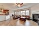 Open-concept living area with a kitchen island, fireplace, hardwood floors and large windows for natural lighting at 4650 Sandy Creek Dr, Cumming, GA 30028