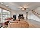 Comfortable living room featuring a fireplace, ceiling fan, large windows and hardwood floors for warm ambiance at 4650 Sandy Creek Dr, Cumming, GA 30028