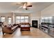 Open living area with fireplace, hardwood floors, large windows, and comfortable leather sofas and ceiling fan at 4650 Sandy Creek Dr, Cumming, GA 30028