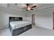 Spacious bedroom features a tray ceiling with fan and a gray bed with storage and headboard with shelving at 4650 Sandy Creek Dr, Cumming, GA 30028