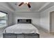 Spacious bedroom features a tray ceiling with fan and a gray bed with storage and headboard with shelving at 4650 Sandy Creek Dr, Cumming, GA 30028