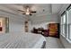 Bright bedroom features a gray bed, a desk, a dresser, carpeted floor, a ceiling fan and a large window at 4650 Sandy Creek Dr, Cumming, GA 30028