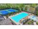 Aerial view of pool and tennis courts, plus a lake, in a well-maintained community at 4650 Sandy Creek Dr, Cumming, GA 30028