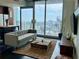 Bright living room featuring a modern sofa, wood accents, and large windows with scenic city views at 860 Peachtree Ne St # 2616, Atlanta, GA 30308