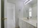 Bright bathroom featuring a large mirror, white vanity, and an open doorway to a naturally lit space at 12554 Huntington Trce, Alpharetta, GA 30005