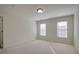Bright bedroom with two windows allowing for natural light and neutral carpeting at 12554 Huntington Trce, Alpharetta, GA 30005