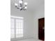 Dining room with white carpet, large window, and elegant chandelier at 12554 Huntington Trce, Alpharetta, GA 30005
