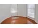 Sunlit entry way with hardwood floors, white door, and windows with blinds at 12554 Huntington Trce, Alpharetta, GA 30005