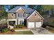Traditional brick home with a two-car garage, manicured lawn, and charming architectural details at 12554 Huntington Trce, Alpharetta, GA 30005