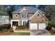 Charming two-story brick home with a well-manicured lawn, two-car garage, and inviting front entry at 12554 Huntington Trce, Alpharetta, GA 30005