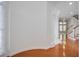 Bright hallway with hardwood floors, curved walls, and staircase in a well-lit home at 12554 Huntington Trce, Alpharetta, GA 30005