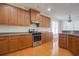 Open kitchen with wooden cabinets, modern appliances, and hardwood floors at 12554 Huntington Trce, Alpharetta, GA 30005