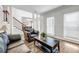 Bright living room featuring hardwood floors, a sitting area, and a staircase with large windows at 3139 Players Dr, Jonesboro, GA 30236