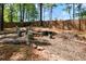Tranquil backyard with mature trees, seating around a firepit, and a wood fence at 561 Valleyside Dr, Dallas, GA 30157