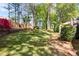 Picturesque backyard with lush green grass, mature trees, and a cozy outdoor seating area at 561 Valleyside Dr, Dallas, GA 30157