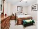 Well-lit bedroom with a wooden bed frame, dresser, and a Masters-themed blanket on the bench at 561 Valleyside Dr, Dallas, GA 30157