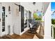 Inviting front porch featuring rocking chairs, wood floors, and a 