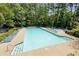 Sparkling community pool with lounge chairs and ample seating surrounded by mature trees at 561 Valleyside Dr, Dallas, GA 30157