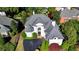 Aerial view of a white home with dark grey roof, circular driveway, and mature landscaping at 7080 Greatwood Trl, Alpharetta, GA 30005