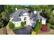 Aerial view of a white home with dark grey roof, circular driveway, and manicured landscaping at 7080 Greatwood Trl, Alpharetta, GA 30005
