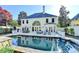 A backyard with a pool, lounge chairs, grill, outdoor dining area, and large home at 7080 Greatwood Trl, Alpharetta, GA 30005