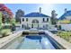 A backyard with a pool, lounge chairs, grill, outdoor dining area, and large home at 7080 Greatwood Trl, Alpharetta, GA 30005
