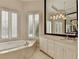 Bright bathroom featuring marble floors, a vanity, and a luxurious soaking tub at 7080 Greatwood Trl, Alpharetta, GA 30005