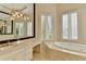 Bright bathroom featuring marble floors, dual vanities, and a luxurious soaking tub at 7080 Greatwood Trl, Alpharetta, GA 30005