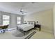 Neutral bedroom boasts a ceiling fan, large windows, and a modern rug under a queen bed and desk at 7080 Greatwood Trl, Alpharetta, GA 30005