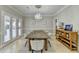 Dining room with a rustic table, chandelier, and natural light streaming through the French doors at 7080 Greatwood Trl, Alpharetta, GA 30005