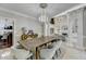 Dining area open to the living room, showcasing a rustic wood table beneath a beautiful chandelier at 7080 Greatwood Trl, Alpharetta, GA 30005
