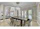 Light-filled dining room with a rustic table and view of the living room and outdoor space at 7080 Greatwood Trl, Alpharetta, GA 30005