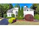 Well-maintained white home with manicured greenery and a vibrant garden at 7080 Greatwood Trl, Alpharetta, GA 30005