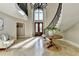 Bright foyer with curved staircase, elegant lighting, and views to the second floor at 7080 Greatwood Trl, Alpharetta, GA 30005