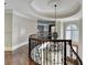 Elegant foyer with curved staircase, dark wood railings, wrought iron spindles, and a large decorative chandelier at 7080 Greatwood Trl, Alpharetta, GA 30005