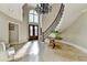 Stunning foyer boasts curved staircase, chandelier, and natural light streaming through large windows at 7080 Greatwood Trl, Alpharetta, GA 30005