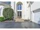 Grand entrance of a white home, featuring arched windows, stone steps and double doors at 7080 Greatwood Trl, Alpharetta, GA 30005