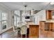 Open-concept kitchen featuring a large island with seating and views of the living area and balcony above at 7080 Greatwood Trl, Alpharetta, GA 30005