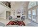 Bright living room with fireplace, built-in shelves and ladder, and views of the outdoor patio through large windows at 7080 Greatwood Trl, Alpharetta, GA 30005