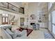 Living room with a soaring ceiling, chandelier, fireplace flanked by built-in shelves, and a staircase leading to the second floor at 7080 Greatwood Trl, Alpharetta, GA 30005