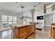 Open floor plan: kitchen with large island, living room with fireplace and soaring windows at 7080 Greatwood Trl, Alpharetta, GA 30005