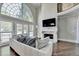 Bright living room with a fireplace, soaring windows, and a comfortable couch at 7080 Greatwood Trl, Alpharetta, GA 30005